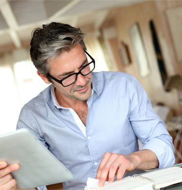 middle-aged relaxed man reviewing business documents in his home office